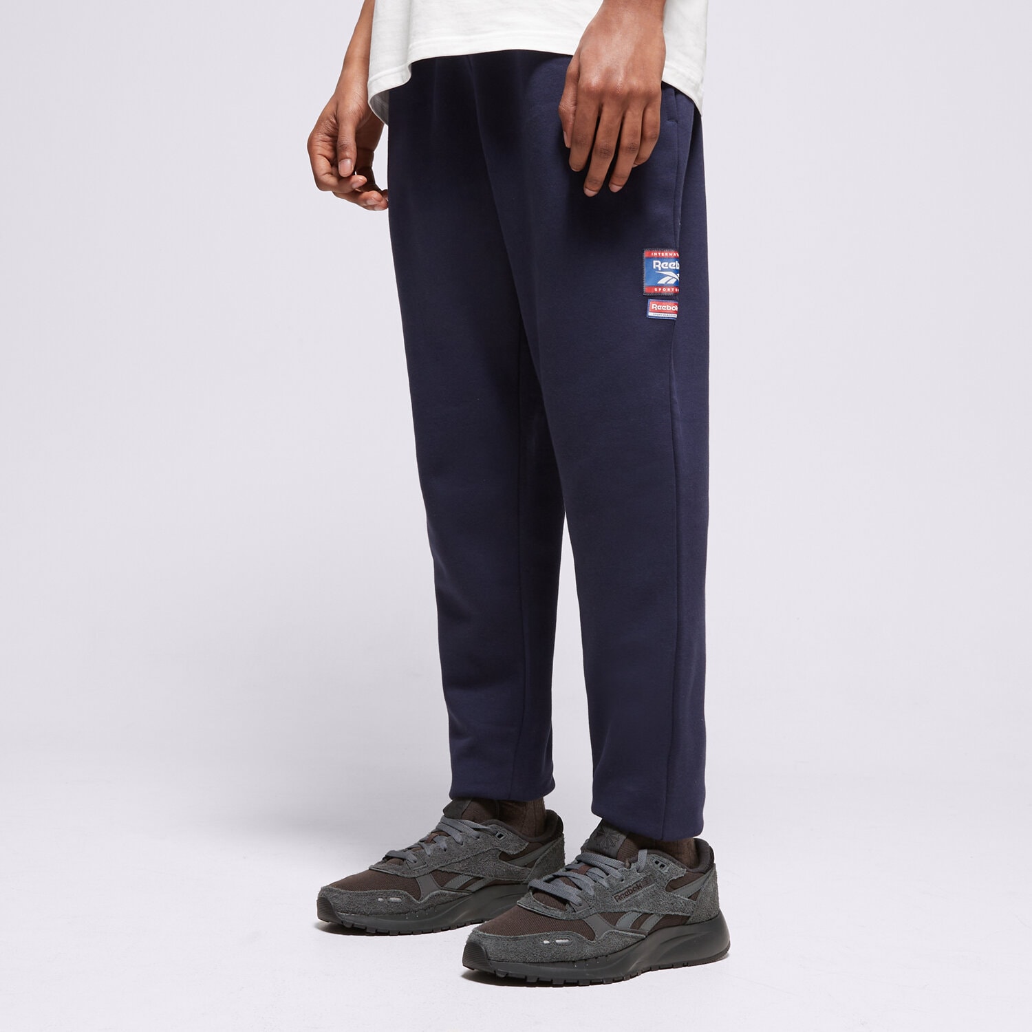 Moški hlače REEBOK HLAČE RI BADGE 100205446 mornarsko modra